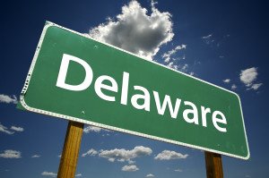 A green road sign with the word delaware on it.